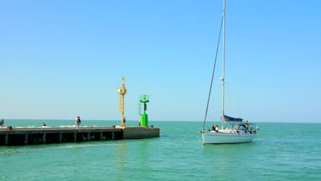 Aufnahme-Eines-Bootes-Mit-Touristen,-Das-Den-Hafen-Zum-Anlegen-In-Cesenatico,-Italien,-Betritt,-Mit-Blick-Auf-Die-Blaue-Adria-Im-Hintergrund-Bei-Tag