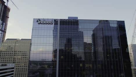 Aerial-view-of-the-mirroring-building-in-Austin,-USA---ascending,-tilt,-drone-shot