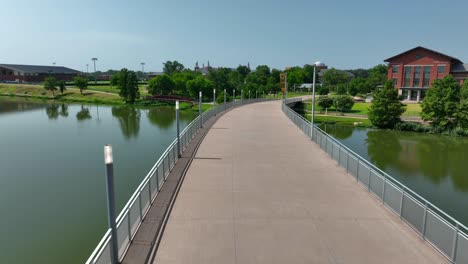 Aéreo-En-El-Campus-De-La-Universidad-De-Baylor,-Cruzando-El-Puente-Sobre-El-Río-Brazos