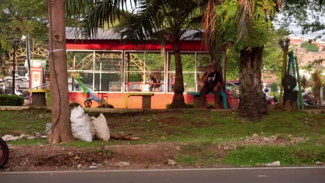 a-man-sitting-on-the-seat-at-city-park,-Semarang,-Central-Java,-Indonesia-on-June-10,-2022