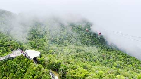 Eine-Drohnenaufnahme-Von-Seilbahnen,-Die-über-Die-üppig-Grünen-Berge-In-Langkawi-Fahren