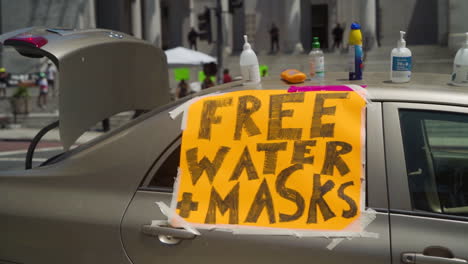 Un-Letrero-Que-Dice-&quot;agua-Y-Máscaras-Gratis&quot;-Pegado-A-Un-Automóvil-En-Una-Protesta-Frente-Al-Ayuntamiento