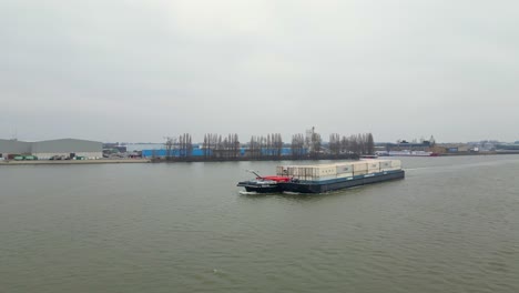 Aerial-View-Of-Denford-Inland-Motor-Freighter-Sailing-Along-Oude-Maas-Carrying-Intermodal-Containers-With-Barge