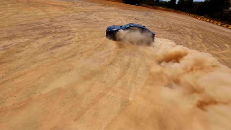 FPV-aerial-following-a-sleek-black-sportscar-drift-through-desert-sand