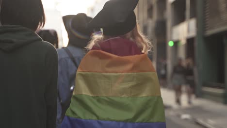 Toma-En-Cámara-Lenta-De-Una-Mujer-Con-Una-Bandera-De-Colores-Del-Arco-Iris-Durante-El-Evento-Del-Orgullo-Lgbt