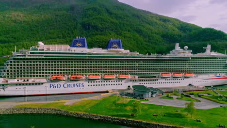 Vista-Aérea-Del-Barco-De-Cruceros-P-Y-O-En-El-Puerto-De-Flam-Con-Montañas-Verdes-En-El-Fondo,-Noruega