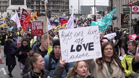 Demonstrators-hold-placards,-banners,-flags-and-march-along-Whitehall-on-the-National-Education-Union-national-strike-protest-in-slow-motion