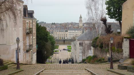 La-Gente-Bajando-Los-Escalones-De-Piedra-En-La-Catedral-De-Saint-Maurice,-Angrys,-Maine-et-Loire,-Francia