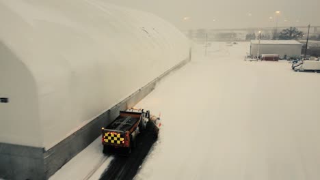 Un-Quitanieves-En-El-Trabajo-Para-Hacer-Frente-A-Las-Enormes-Cantidades-De-Nieve-Alrededor-De-Un-Hangar-En-Toronto,-Ontario,-Canadá