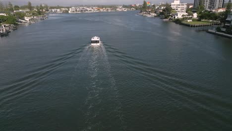 5-February-2023---Aerial-views-over-boat-on-canal-in-Surfers-Paradise,-Gold-Coast,-Queensland,-Australia