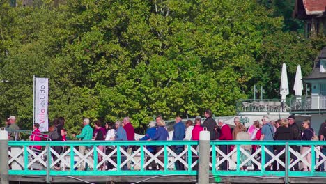 Passagiere-In-Einer-Schlange-An-Einem-Dock-Am-Wörthersee,-Die-An-Einem-Schönen-Und-Sonnigen-Tag-Darauf-Warten,-An-Bord-Eines-Bootes-Zu-Gehen