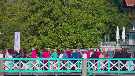 Passagiere-In-Einer-Schlange-An-Einem-Dock-Am-Wörthersee,-Die-An-Einem-Schönen-Und-Sonnigen-Tag-Darauf-Warten,-An-Bord-Eines-Bootes-Zu-Gehen