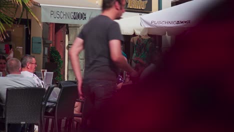 People-sit-at-a-sidewalk-cafe-on-Old-Square-in-the-city-center-of-Klagenfurt-enjoying-a-warm-and-sunny-day