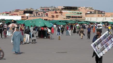 Statische-Ansicht-Von-Einheimischen-Und-Touristen,-Die-Tagsüber-Auf-Dem-Belebten-Platz-Djemaa-El-Fna-Flanieren