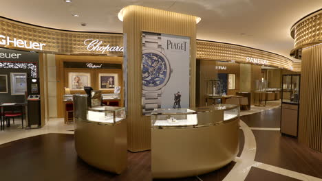 El-Interior-De-La-Tienda-De-Relojes-De-Lujo-Avanza-Hacia-El-Mostrador-De-Exhibición-De-Ventas-De-Marketing-Minorista-De-Oro-Piaget