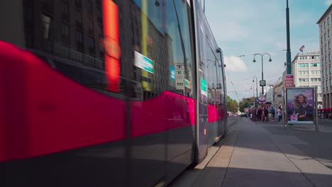 Two-trams-arrive-at-a-tram-stop-on-Opernring-in-Vienna