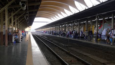 Crowd-of-passengers-walking-towards-exit-on-train-station-platform,-Bangkok,-Thailand