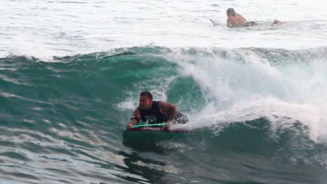 Toma-En-Cámara-Lenta-De-Bodyboarder-Rociando-Lavado-Blanco-Mientras-Monta-La-Ola