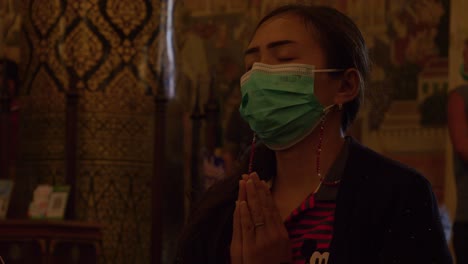 Close-up-view-of-Asian-woman-with-hands-together-praying-Buddha-at-Buddhist-temple,-Thailand