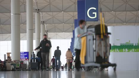 Los-Pasajeros-De-Viaje-Caminan-Hacia-Los-Mostradores-De-Facturación-De-La-Aerolínea-Ubicados-En-La-Sala-De-Salidas-Del-Aeropuerto-Internacional-Chek-Lap-Kok-De-Hong-Kong