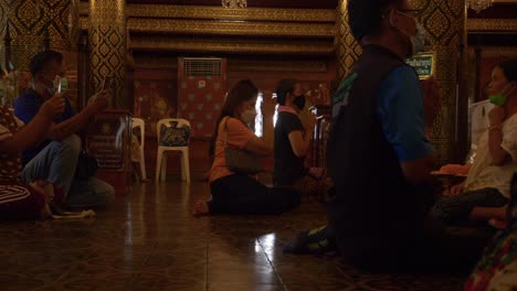 Männer-Und-Frauen-Beten-Zu-Buddha-Im-Buddhistischen-Tempel,-Wat-Phra-Sri-Rattana-Mahathat,-Thailand