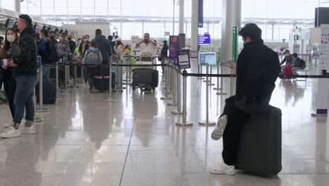 Travel-passengers-check-in-at-an-airline-desk-counter-in-Hong-Kong's-Chek-Lap-Kok-International-Airport