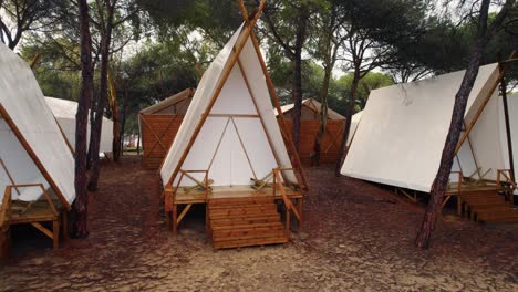 Imágenes-Deslizantes-De-Un-Camping-Con-Carpas-Blancas-Puntiagudas-Sobre-Plataformas-De-Madera-En-Huelva-España