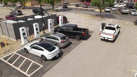 Coches-Eléctricos-Cargando-En-La-Estación-De-Carga-Local-En-EE.UU.,-Vista-Aérea-De-Drones