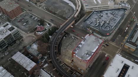 Commuter-trains-driving-over-streets-in-Lincoln-Park,-Chicago,-USA---Aerial-view