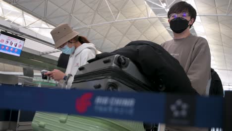 Travel-passengers-queue-in-line-to-check-in-at-the-Air-China-airline-desk-counter-at-Hong-Kong's-Chek-Lap-Kok-International-Airport