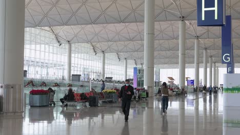 Los-Pasajeros-Chinos-De-Viaje-Caminan-Hacia-Los-Mostradores-De-Facturación-De-La-Aerolínea-Ubicados-En-La-Sala-De-Salidas-Del-Aeropuerto-Internacional-Chek-Lap-Kok-De-Hong-Kong