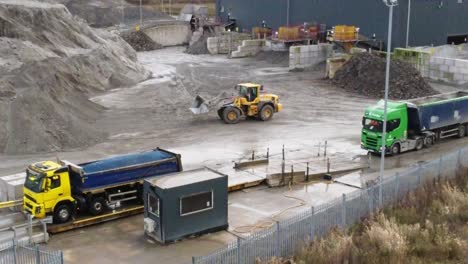 Aerial-view-trucks-waiting-to-check-load-on-industrial-lorry-weigh-station-construction-site