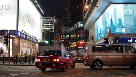 Personas-Y-Automóviles-En-Una-Calle-Concurrida-Iluminada-Por-Vallas-Publicitarias