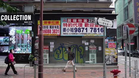 Anuncios-De-Alquiler-Y-Afiches-Colocados-En-Tiendas-En-Tsim-Sha-Tsui-En-La-Calle-Y-Peatones-Asiáticos-Con-Mascarillas-Circulando