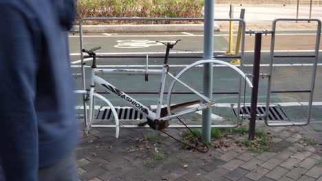 13-De-Febrero-De-2023---Bicicleta-Blanca-Abandonada-Colgando-De-Barandillas-Sin-Ruedas-En-Tseung-Kwan-O,-Hong-Kong