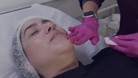 Esteticista-Anónimo-Frotando-Gel-Anestésico-En-La-Cara-Del-Paciente-Antes-De-La-Cirugía-Estética