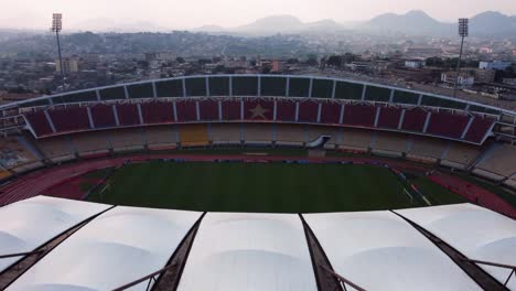 Ascending-aerial-view-revealing-the-field-of-the-Stade-Omnisports-Ahmadou-Ahidjo-stadium,-in-Yaounde,-Cameroon