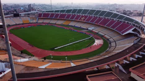 Aerial-tracking-view-of-the-Stade-Omnisports-Ahmadou-Ahidjo-stadium,-sunny-evening-in-Yaounde,-Cameroon