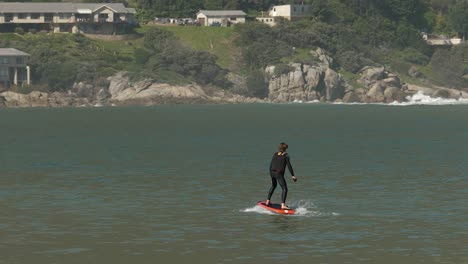 Junger-Mann-Fährt-Gerne-Fliteboard-Power-Hydrofoil-Surfbrett-Vor-Der-Küste