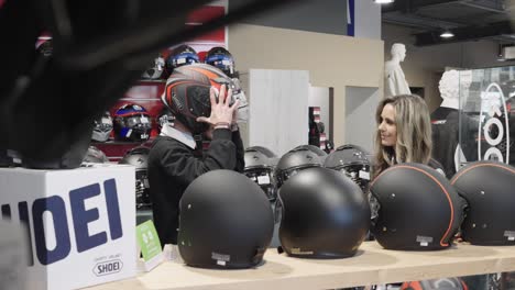 Una-Vendedora-En-Una-Tienda-De-Accesorios-Para-Motocicletas-Tiene-Cascos-De-Prueba-Para-Un-Cliente