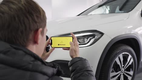 Un-Joven-Toma-Una-Foto-Del-Faro-Delantero-De-Su-Auto-Blanco