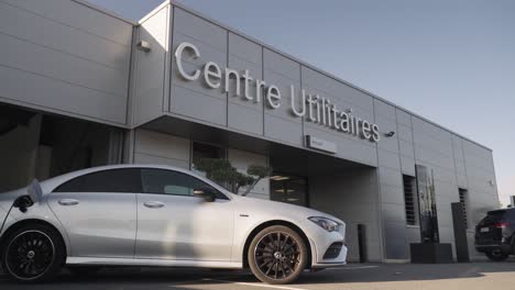 A-gray-electric-car-in-front-of-a-dealership's-utility-center