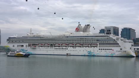 Die-Fähre-Fährt-Vom-Fährterminal-Am-Hafen-Vor-Dem-Hintergrund-Des-Resorts-World-Cruises,-Sentosa-Island,-Weg