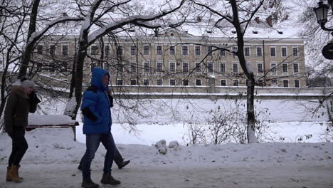 In-Zeitlupe-Gehen-Männer-Und-Frauen-In-Winterkleidung-Einen-Schneebedeckten-Weg-Entlang-Und-Kommen-An-Der-Burg-Rzeszow-Vorbei