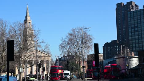 Buses-Driving-past-St-John's-Church,-Waterloo,-London,-United-Kingdom