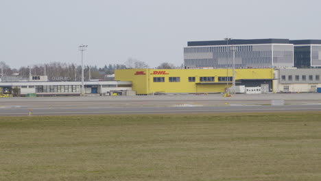 Alejar-La-Toma-Del-Edificio-Dhl-En-El-Aeropuerto-Lecha-Wałęsy-En-Gdansk---Toma-Amplia