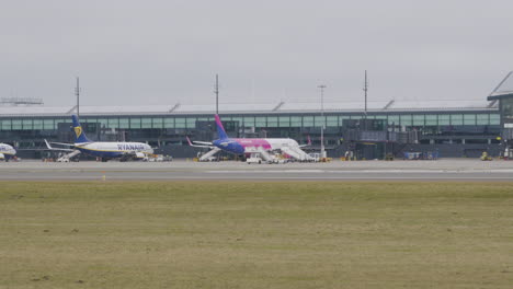 Aviones-De-Las-Aerolíneas-De-Bajo-Costo-Wizzair-Y-Ryanair-Se-Paran-Frente-A-La-Terminal-De-Salida-En-El-Aeropuerto-De-Gdansk-Esperando-A-Los-Pasajeros