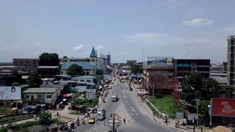 Aerial-pull-back-shot-over-the-Rond-Point-Deido-roundabout-in-Douala-city,-Cameroon,-Africa