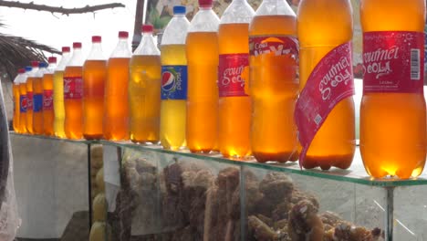 Fila-De-Bebidas-Azucaradas-Embotelladas-En-La-Parte-Superior-De-La-Caja-De-Desplazamiento-Al-Aire-Libre-Que-Vende-Grumos-De-Jaggery-Gur-En-Punjab