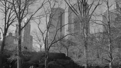 Monochrome-Image-Of-People-Climbing-On-Rocks-At-Central-Park-On-A-Sunny-Winter-Day-In-NYC,-USA